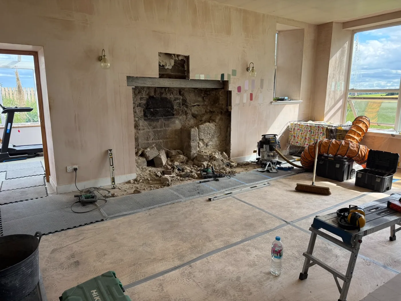 A fireplace opening stripped back to bare stone ready for a new stove