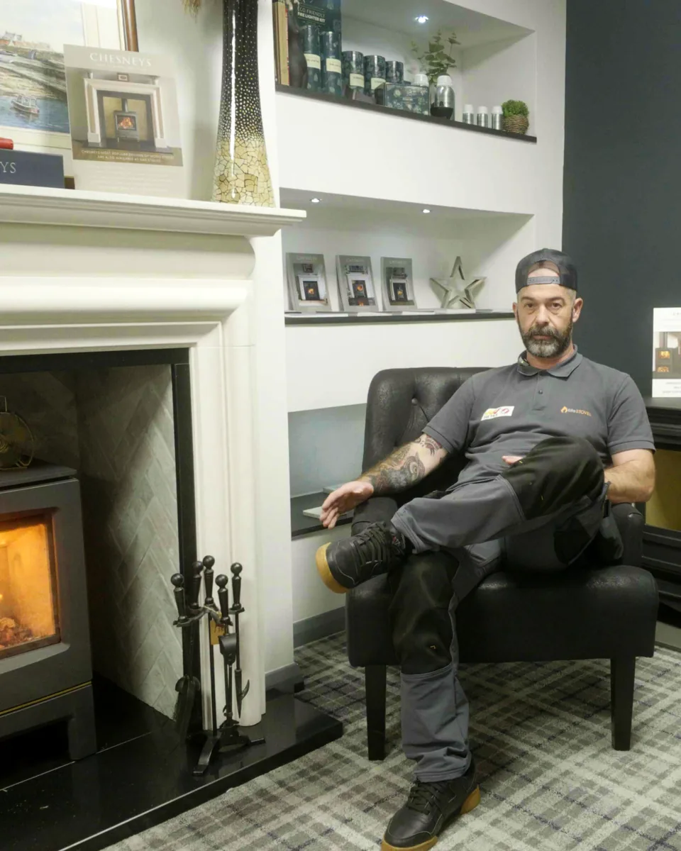 Chad Reekie, Director of Fife Stoves, beside a lit stove in the Kirkcaldy showroom